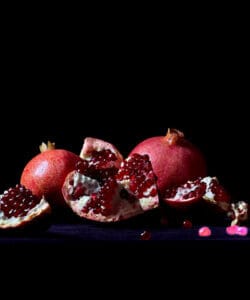 Low-light food shot captured using telephoto lens iPhone showing detailed pomegranate texture