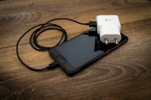 Smartphone with charger included, showing accessories to provide while selling old mobile phone
