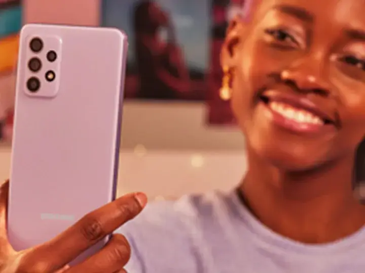 1000106253 Person holding a Samsung Galaxy A-series smartphone in lavender color, showing the rear camera design