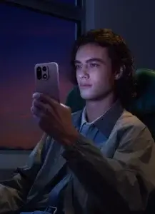 Person holding the OnePlus 15 5G at night, demonstrating display clarity and design in the purple color variant.