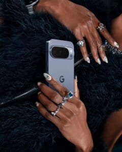 Person holding Google Pixel phone with stylish rings and accessories