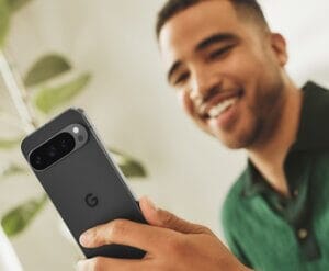 Man smiling while using Google Pixel smartphone indoors